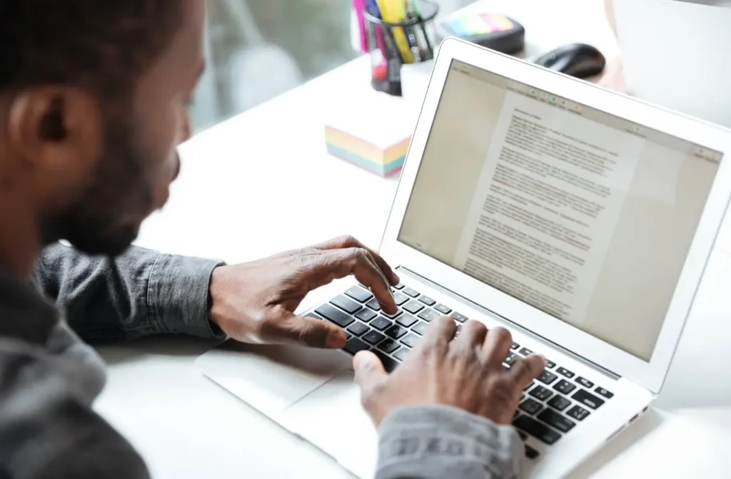 Author reviewing manuscript on laptop