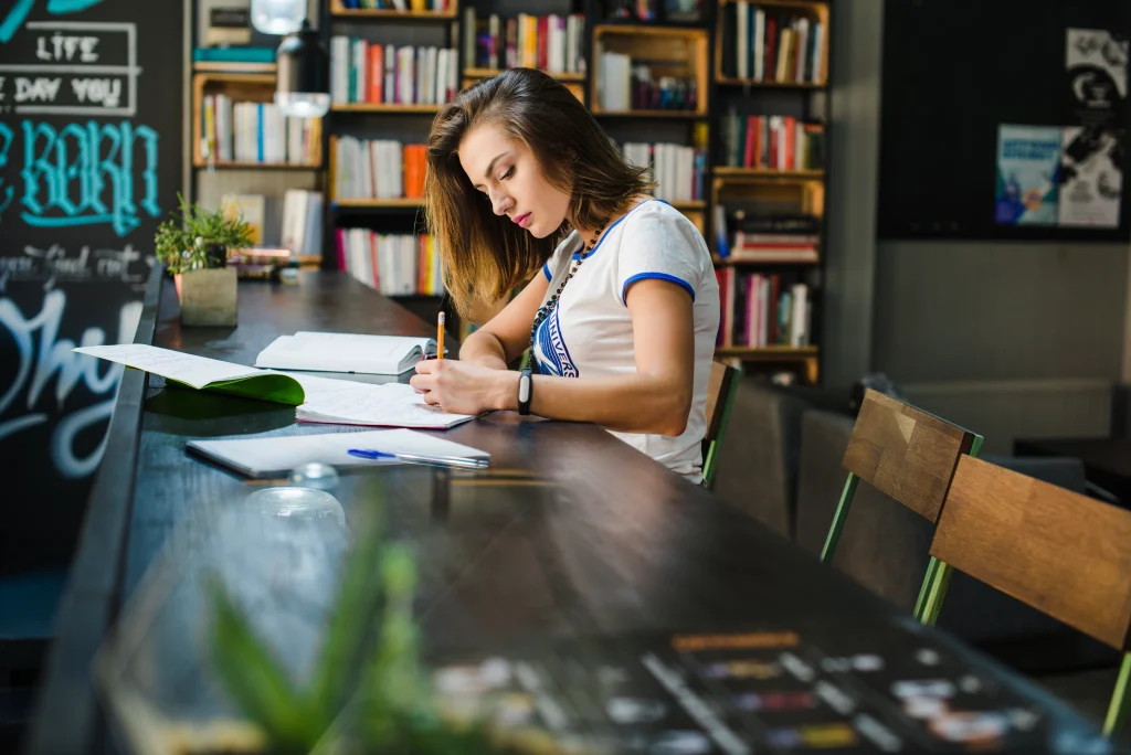girl-sitting-table-with-notebooks-writing